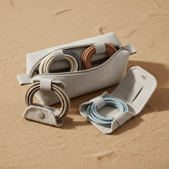 Neutral cable organizer kit with neatly coiled cables on warm sand